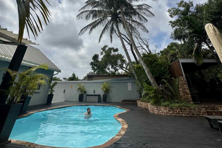 Man in zwembad in het dorpje St. Lucia in Zuid-Afrika