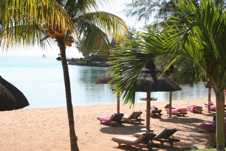 Strand op Mauritius met palmbomen en ligbedjes