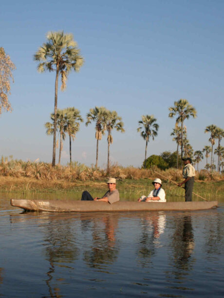 Echtpaar vaart door de Okavango Delta in een mokoro met een polar gids.