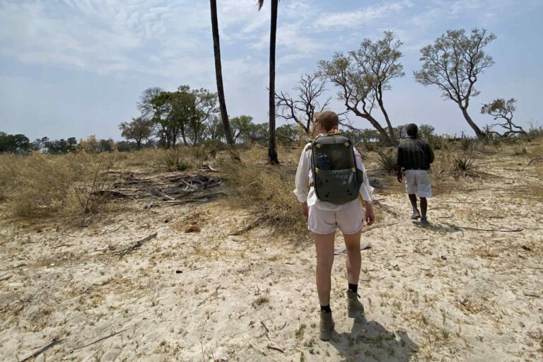 Gids en vrouw wandelen in de Okavango Delta